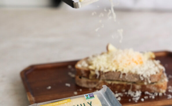 maker;s blend cheese being grated onto bread